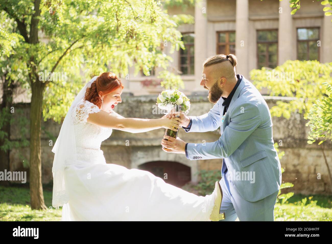 Just married loving hipster couple in wedding dress and suit in the park.  Happy bride and groom walking running and dancing. Romantic Married young fa  Stock Photo - Alamy