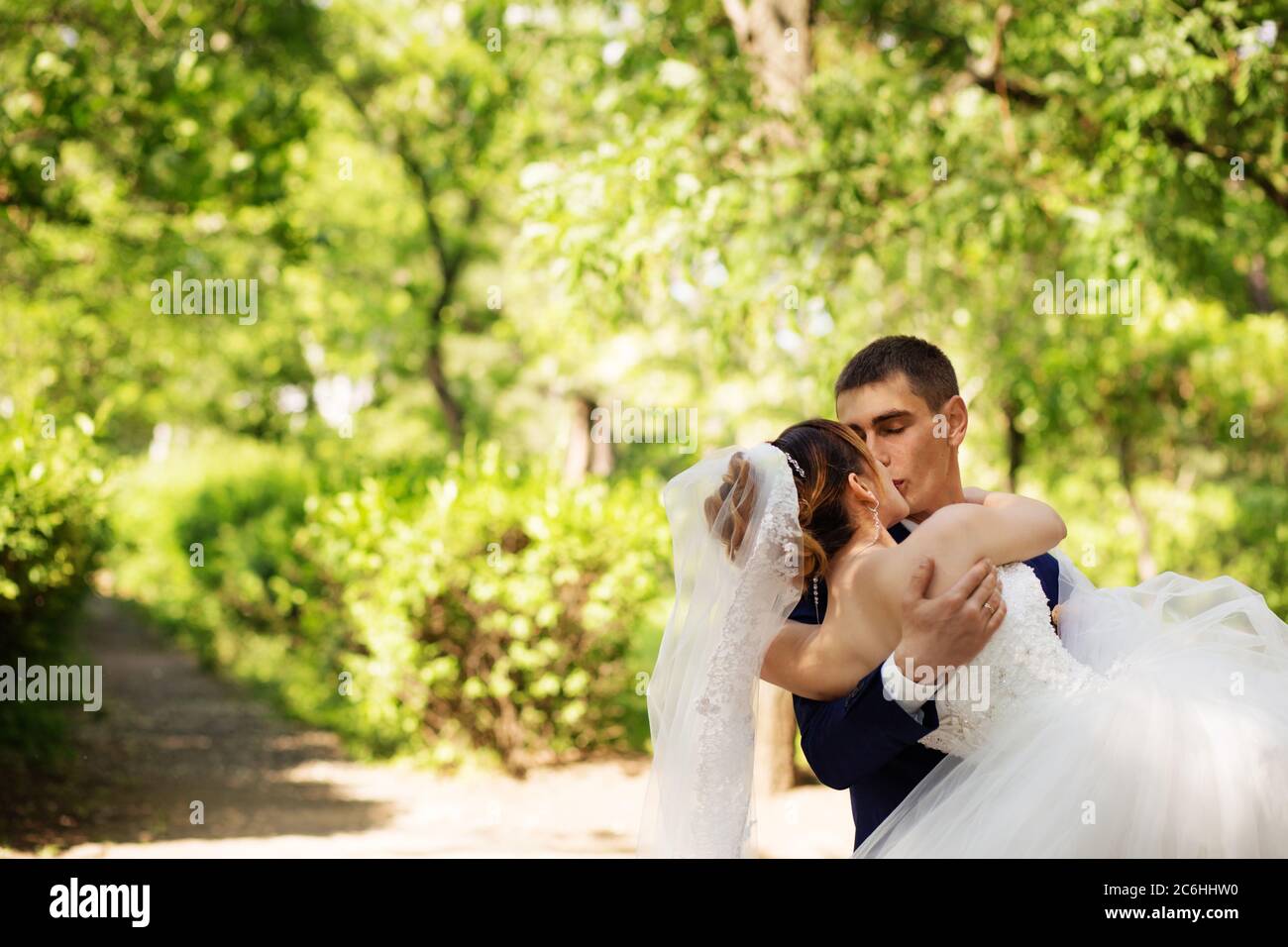 Kissing loving newlyweds. Bride and groom kissing in the park Stock ...