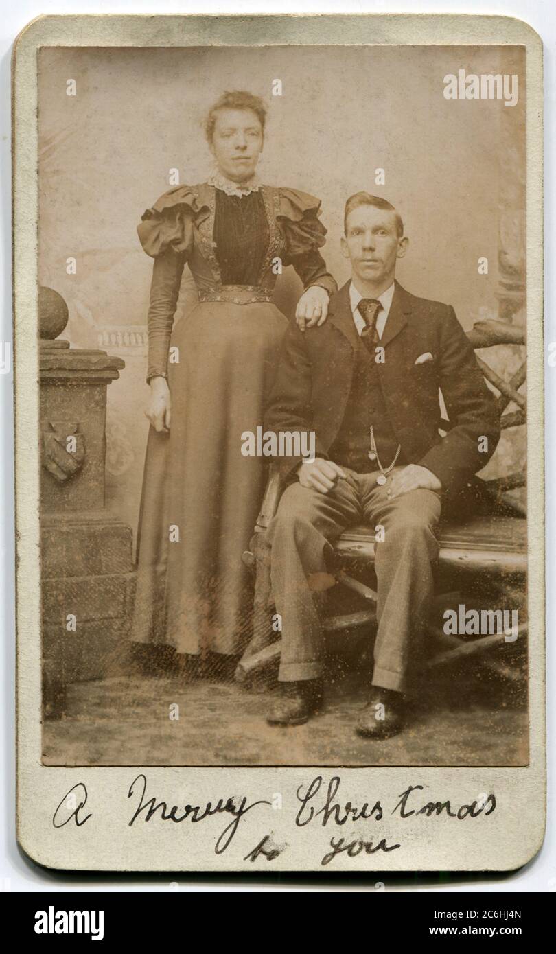 Circa 1890s. A carte de visite photograph of a Victorian couple. A handwritten caption below: 'A Merry Christmas to You' Stock Photo