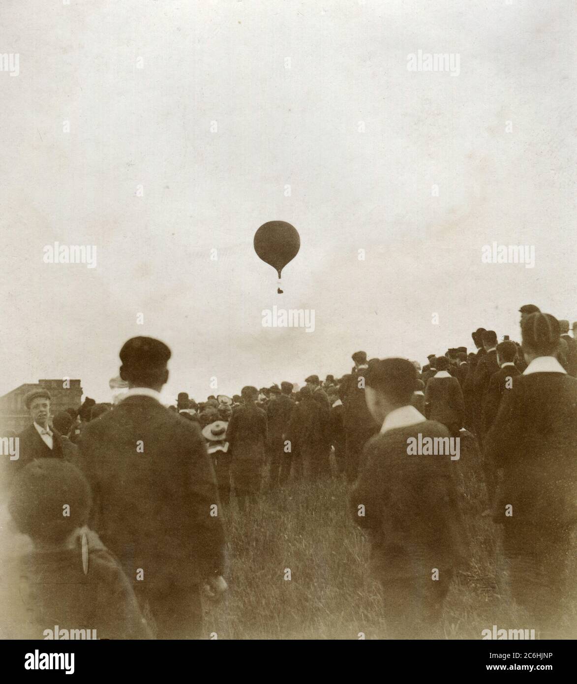 Circa 1900. Children watching a hydrogen balloon take to the air. Stock Photo