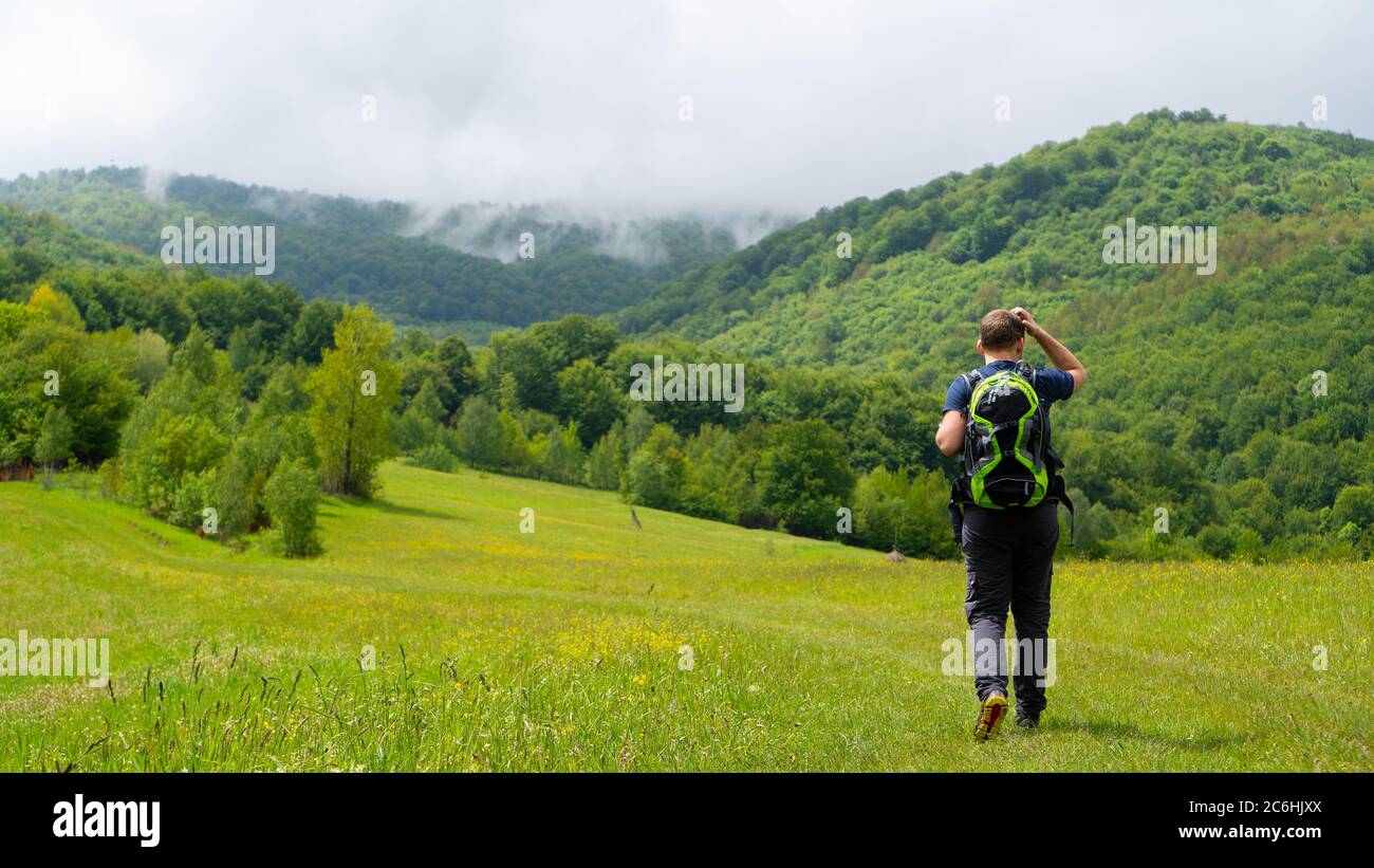 quarantine in the mountains. weekend hiking. Man backpacker hiking in mountains alone. mountain view in the fog Stock Photo