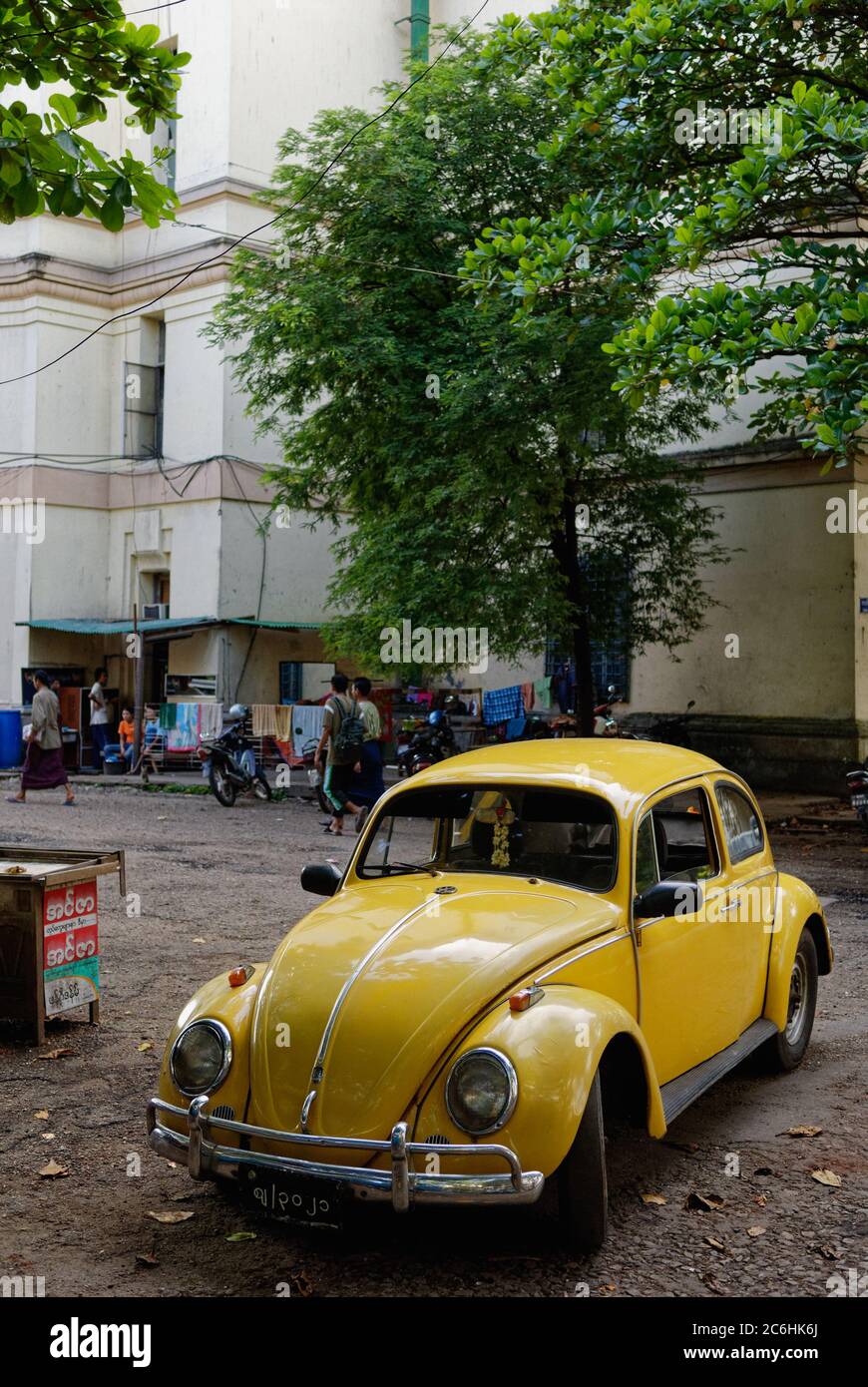 Yellow Volkswagen beetle car parking in downtown Yangon, Myanmar Stock Photo