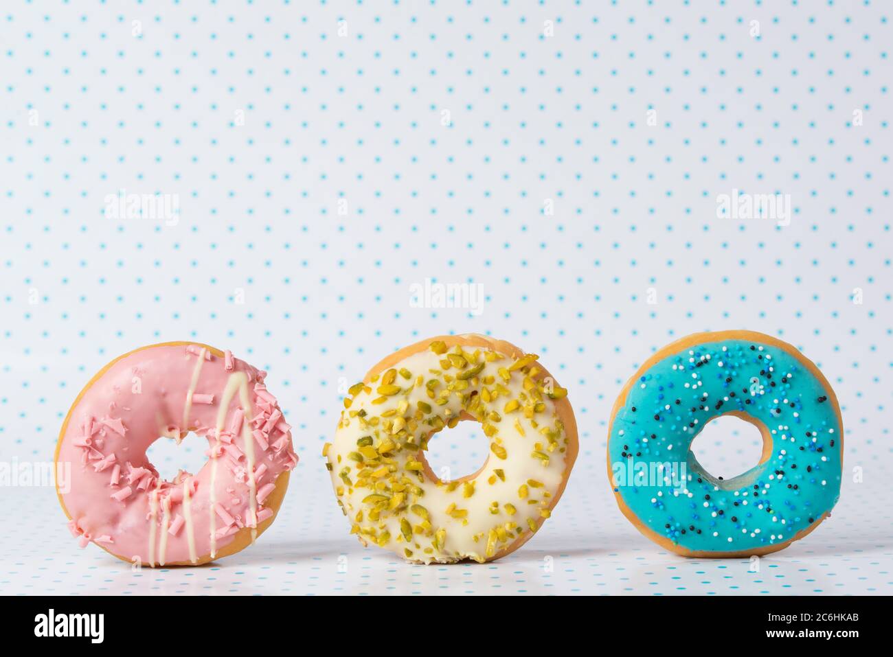 Pink, green and blue donuts on polka dots background Stock Photo