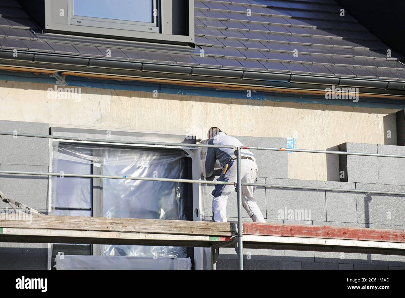 Construction workers insulates house facade Stock Photo