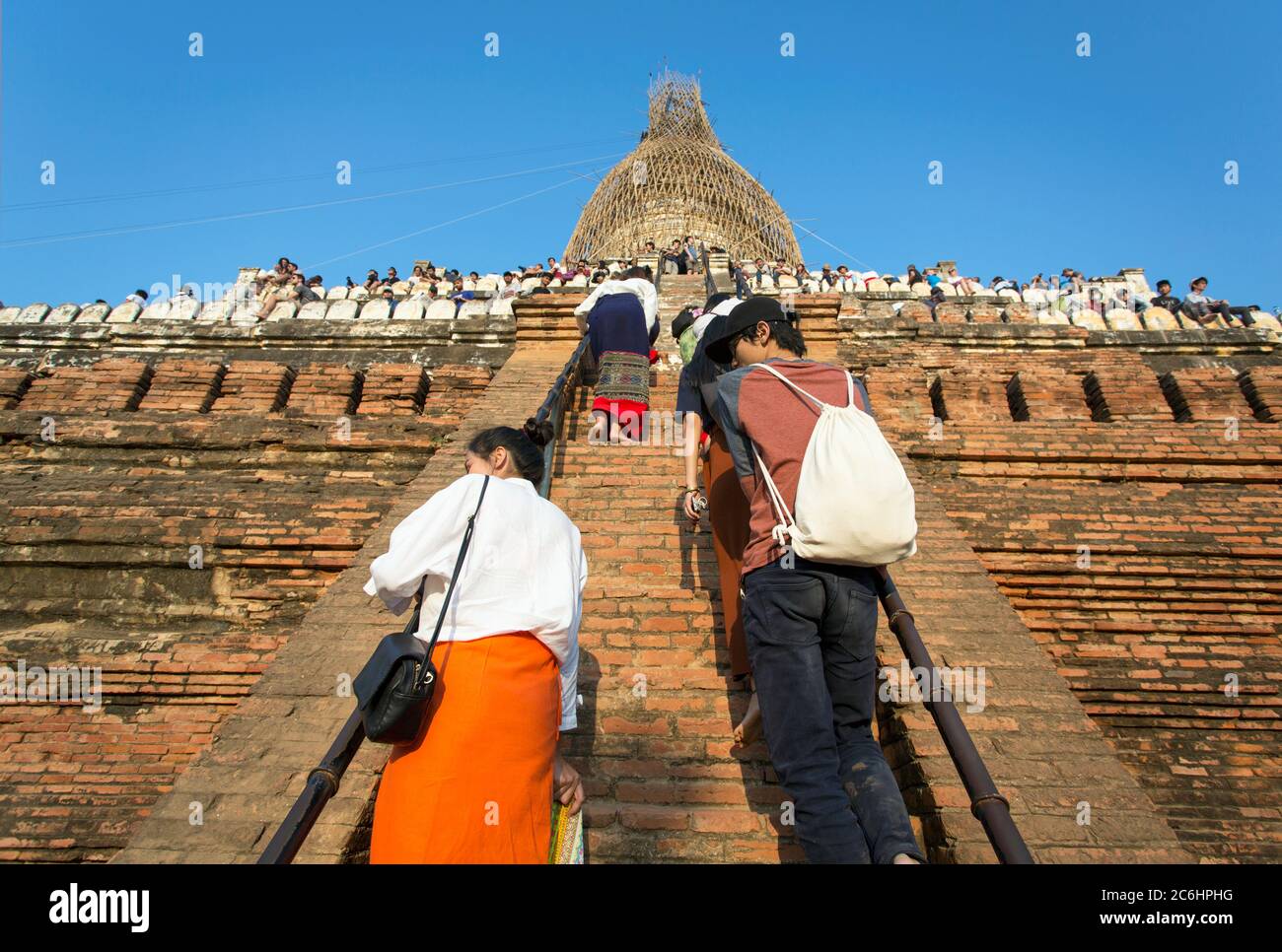 Tourists climb up the steep staircase to watch the sunset at a temple in Old Bagan, Myanmar Stock Photo