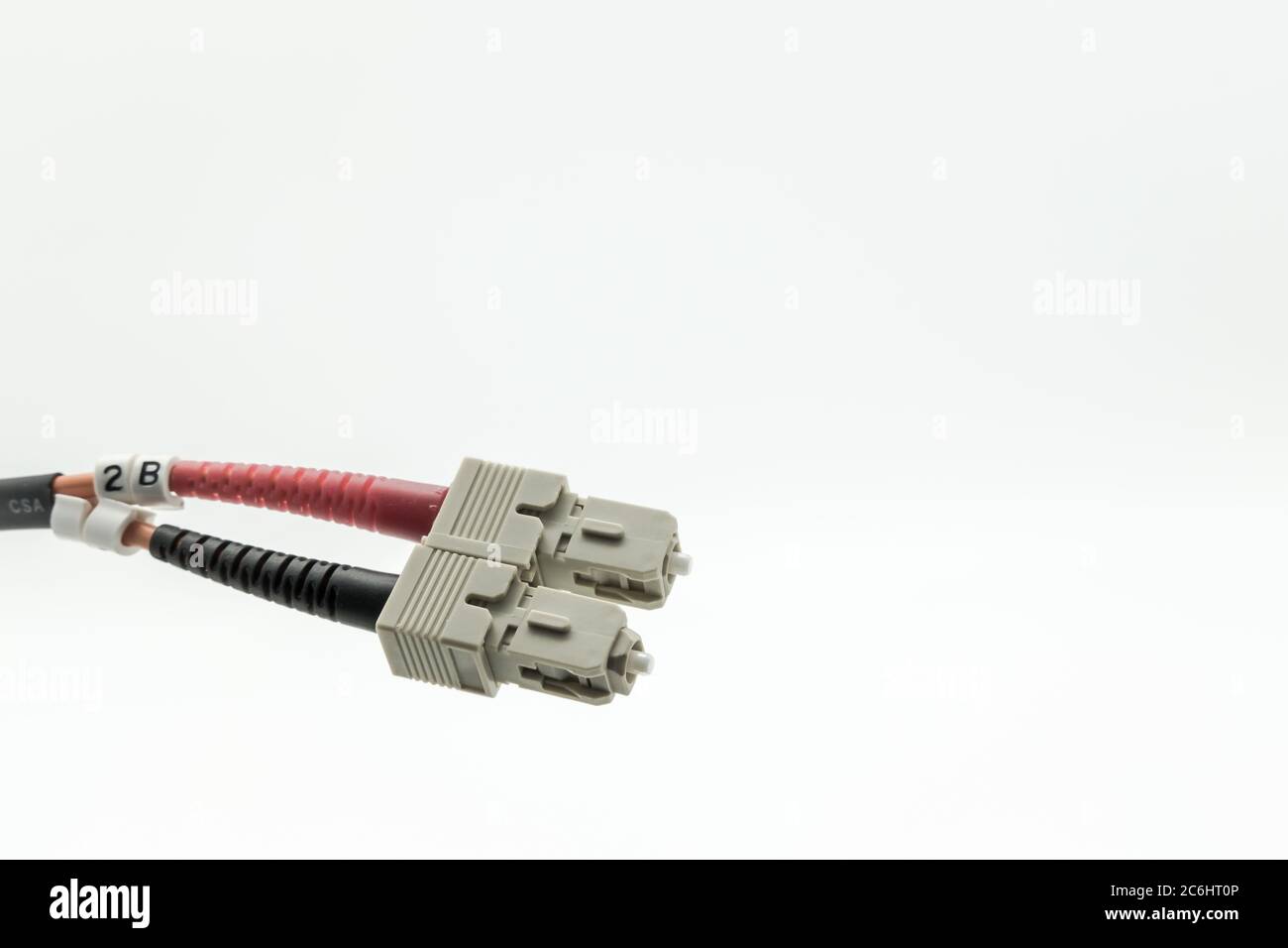 Macro image of super-fast Internet fibre optic patch leads used for high-speed, optical networking connections. Shown as a duplex pair of connectors. Stock Photo
