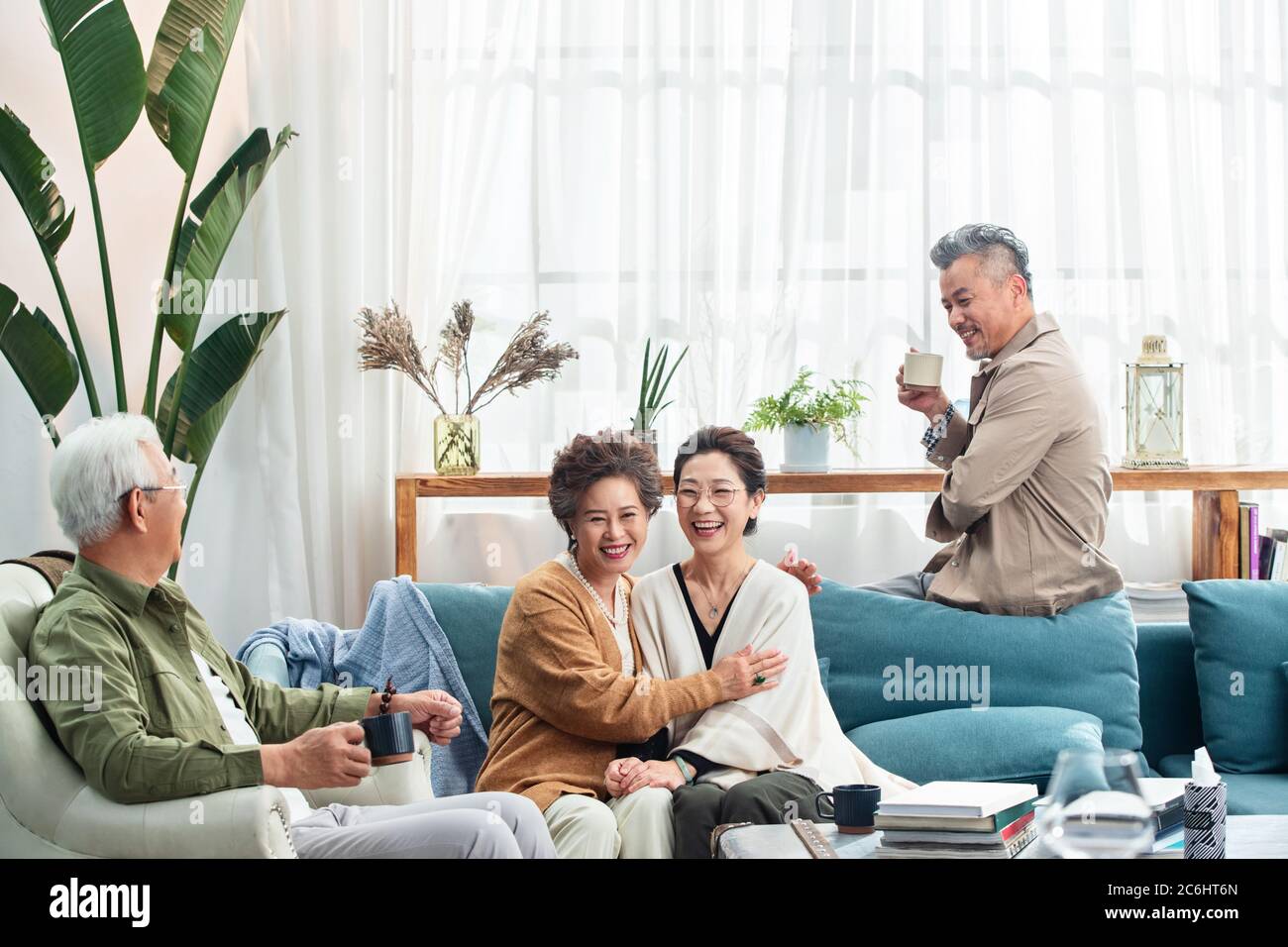 Happy middle-aged couples chat over a cup of tea Stock Photo - Alamy