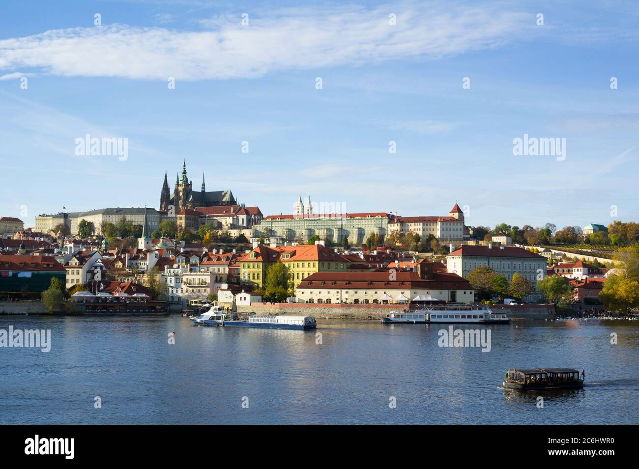 Prague Castle, Hradcany, Prague, Czech Republic / Czechia - panorama of historical part of the city. Dominant towers of Saint Vitus Cathedral. Boats w Stock Photo