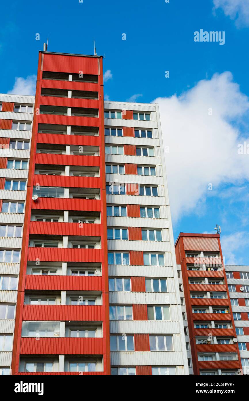 Blocks of flats made during era of socialism in eastern bloc. Facade of architecture has bright red color. Low angle shot with blue sky Stock Photo
