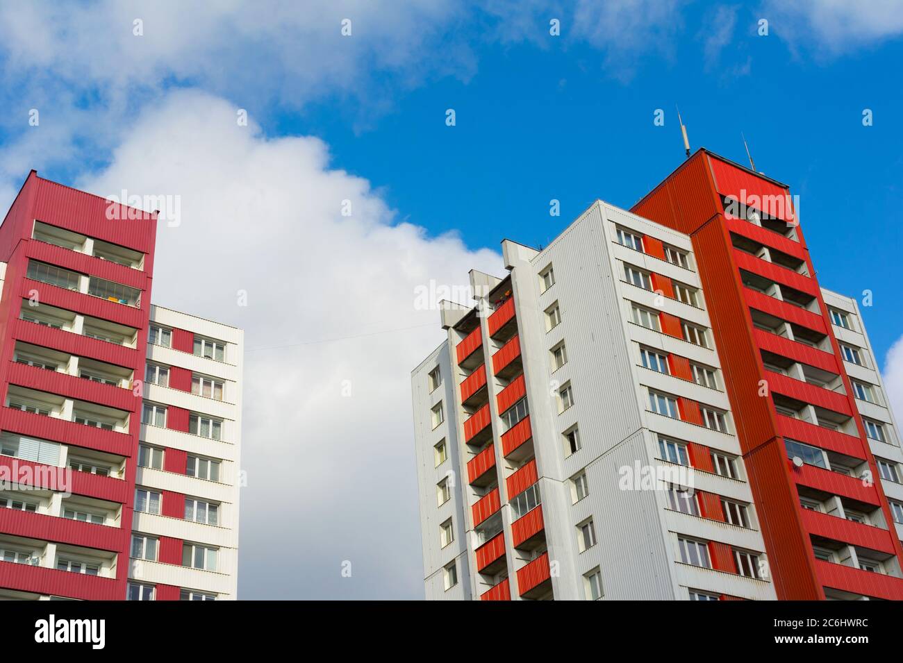 Blocks of flats made during era of socialism in eastern bloc. Cheap social housing for poor people today. Facade of architecture has bright red color. Stock Photo