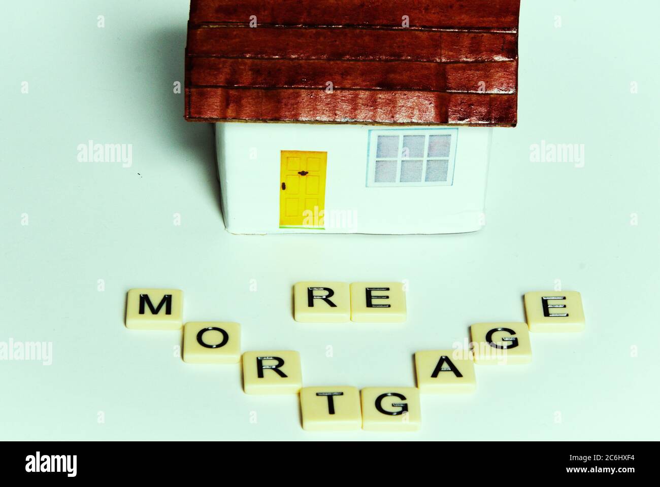 Financial concept image. simle toy house. Cost of  Covid 19 to economy and savings. Need to re-mortgage, take money out of property to survive.  Words Stock Photo