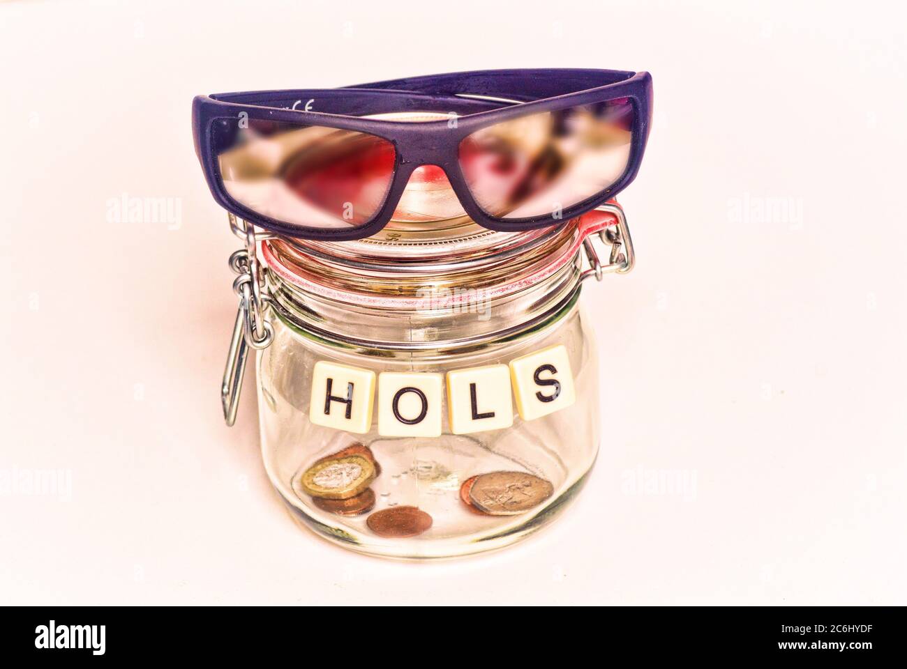 Financial concept image. Cost of  Covid 19 to economy and savings.  Almost empty jar for holiday savings. Sun glasses.   None. Poverty.   Idea shortag Stock Photo