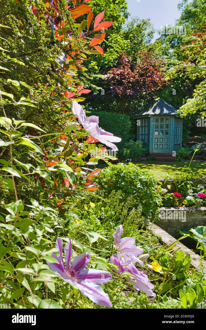 House Back garden from kitchen window, with bespoke summerhouse and beautiful flower displays, enclosed by trees, secluded, design, Central Scotland, Stock Photo