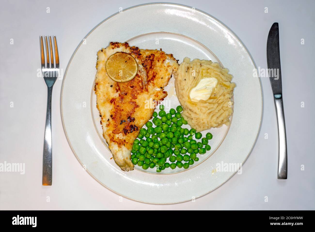 Lightly fried breaded plaice, mashed potatoes and peas Stock Photo