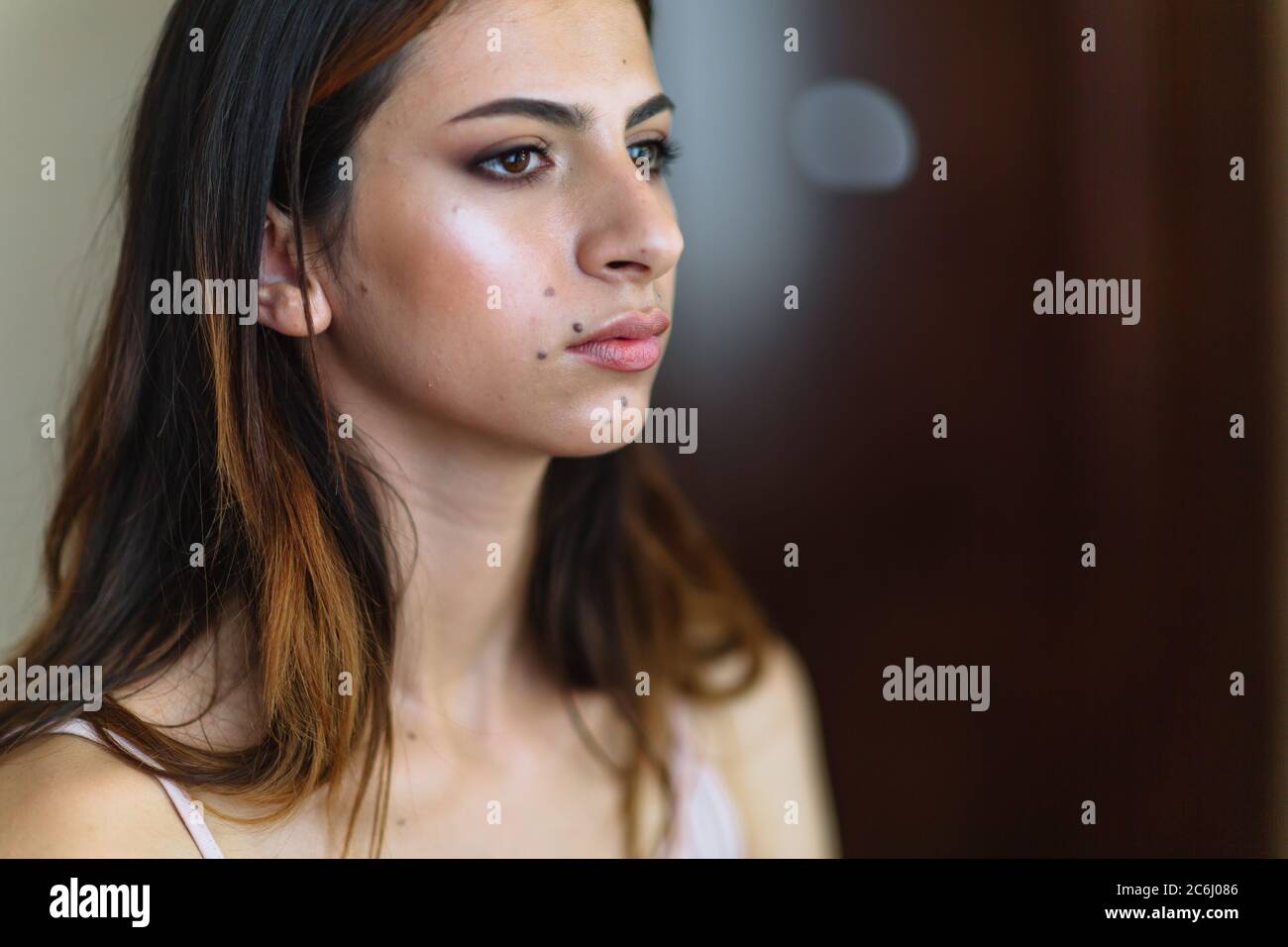 Beautiful model in make up process. Portrait of young pretty woman with beutiful makeup in beauty studio salon. Evening make up, blurry background Stock Photo