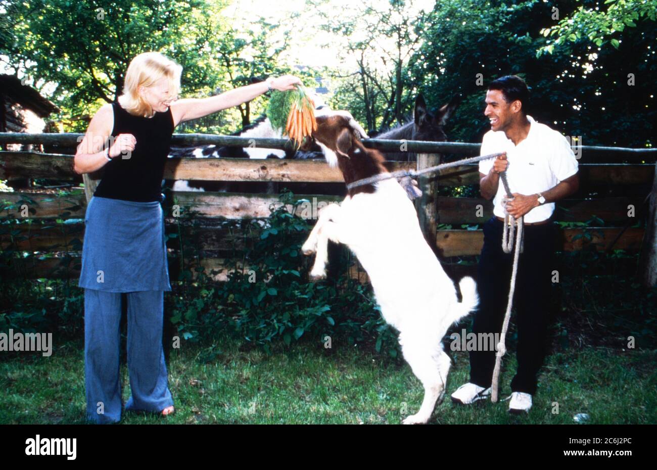 Michael Dierks und Diana Staehly, beide Schauspieler, füttern eine Ziege mit Karotten, Deutschland 1999. Stock Photo