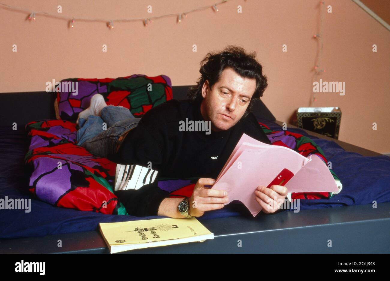 Kay Sabban, deutscher Schauspieler, lernt seinen Text im Bett in Hamburg, Deutschland 1990. Stock Photo