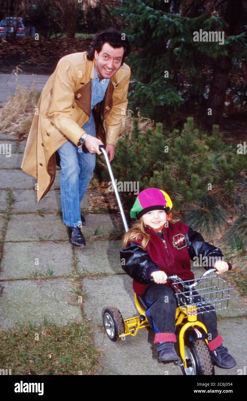 Kay Sabban, deutscher Schauspieler, schiebt seine Tochter auf dem Dreirad  auf der Terrasse in Hamburg, Deutschland 1990 Stock Photo - Alamy