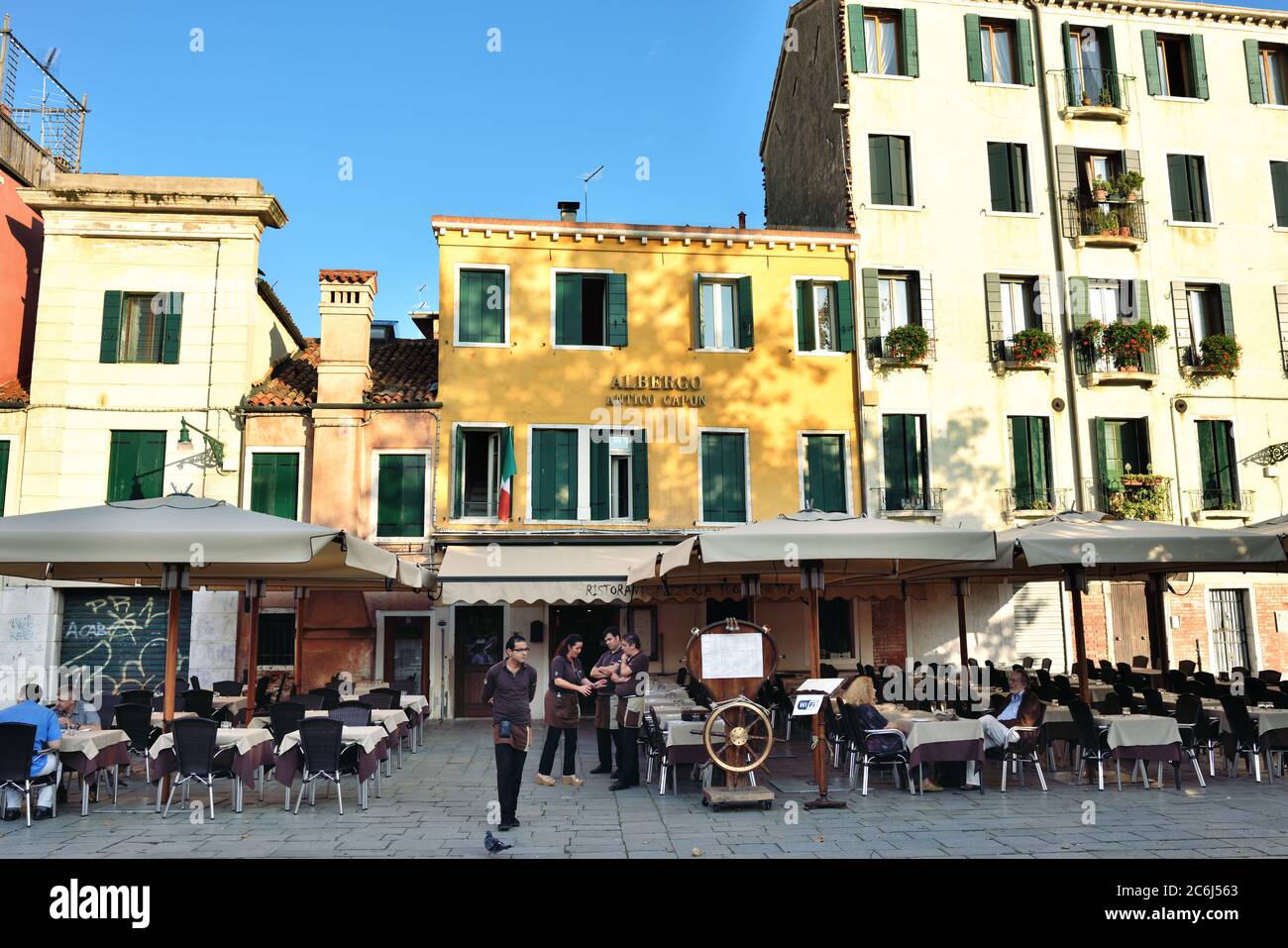 Venice, italy - Sept 27, 2014: Campo Santa Margherita at sunrise. A street restaurant staff awaits visitors for dinner Stock Photo