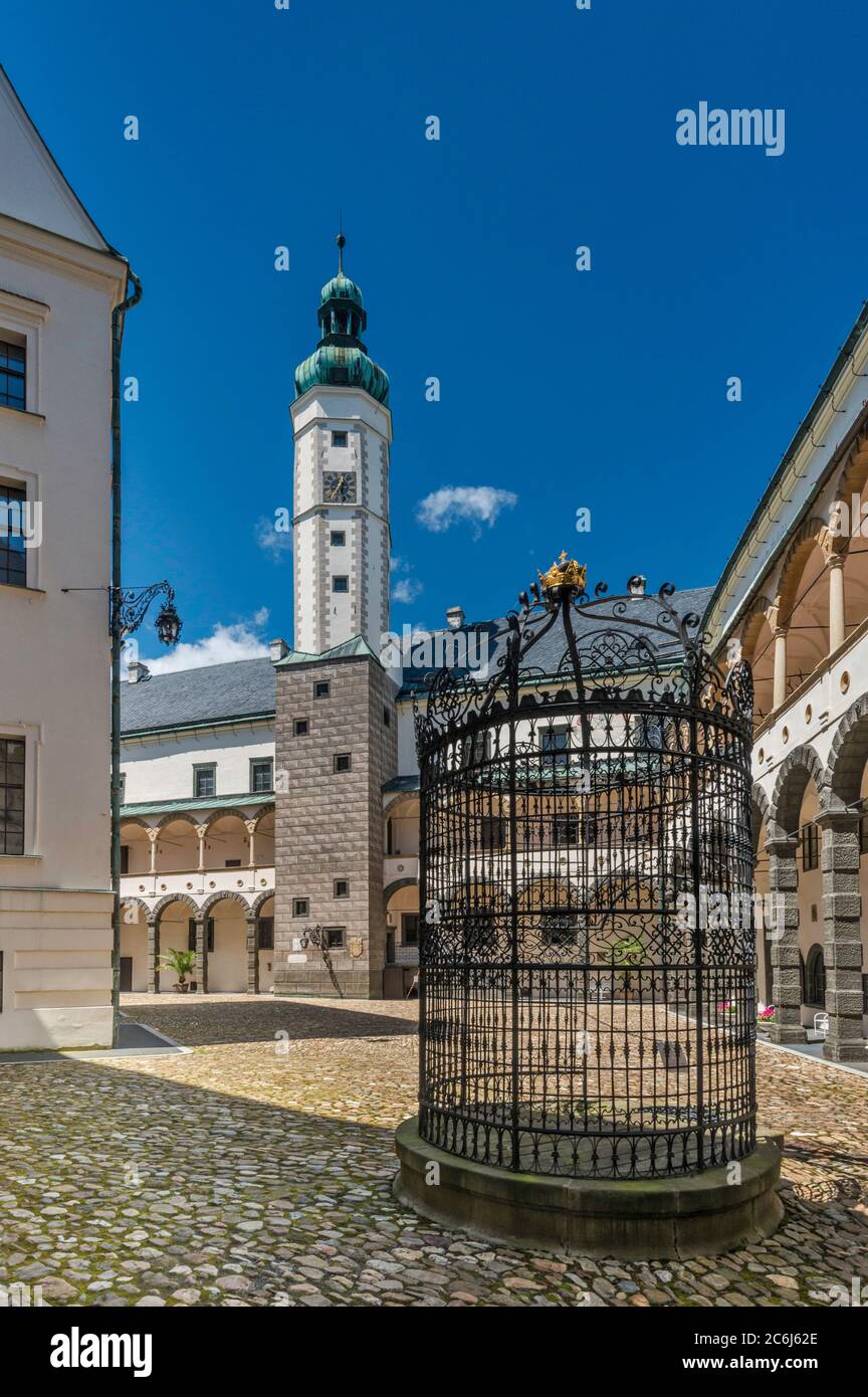 Water well, wrought iron enclosure, arcades and tower at courtyard of Castle in Bruntal, Czech Silesia, Moravian-Silesian Region, Czech Republic Stock Photo