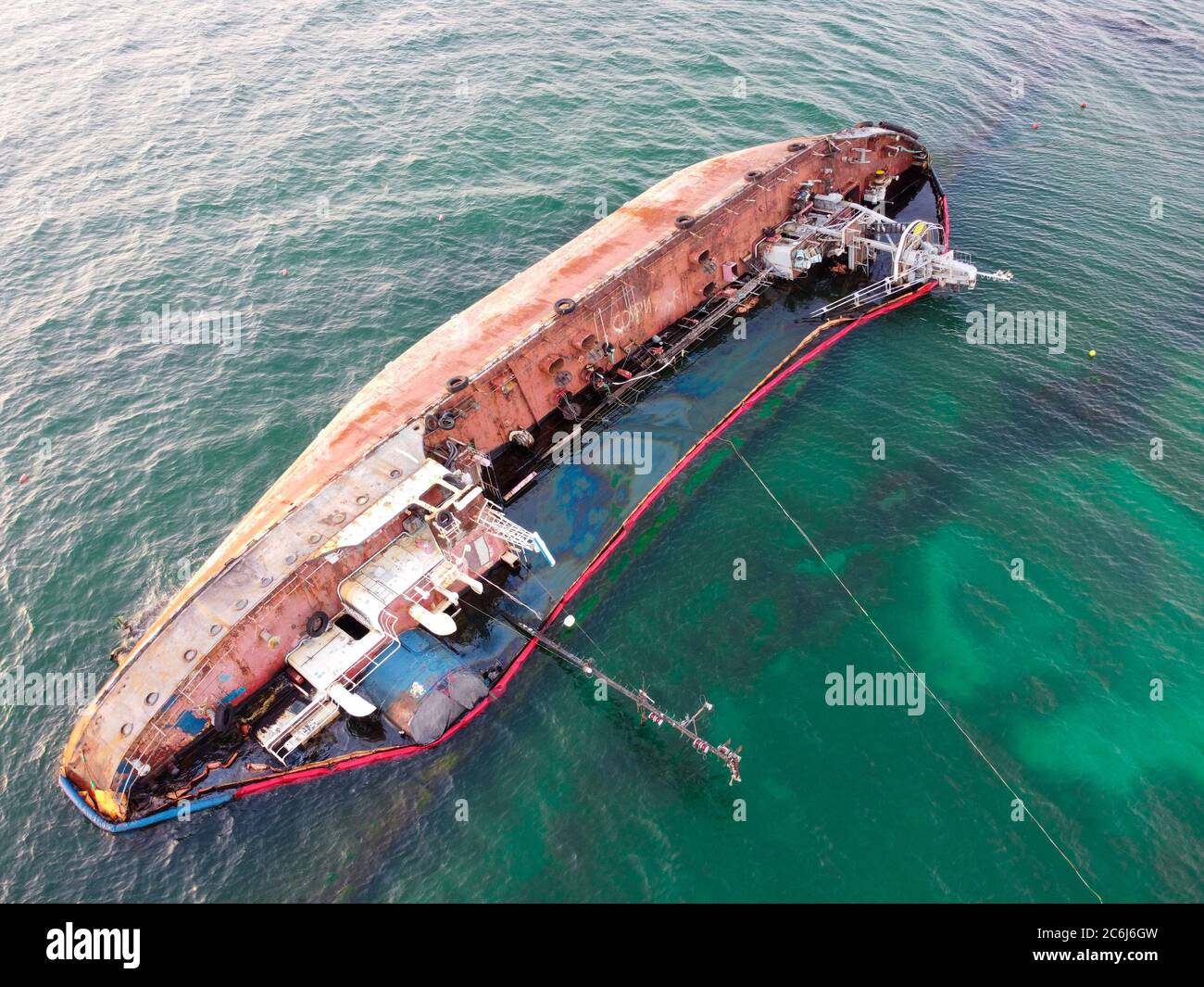 A tanker that sank on the seashore, an environmental catastrophe, pollution of fuel and oil products of the shoreline at sea. Stock Photo