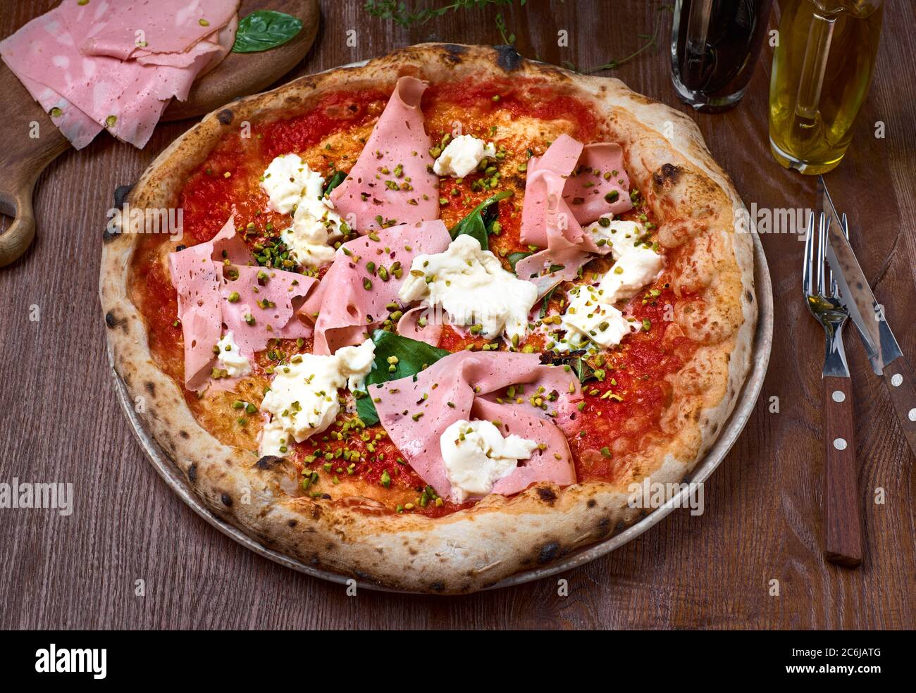 Italian pizza with mortadella and cheese on dark a wooden table ...