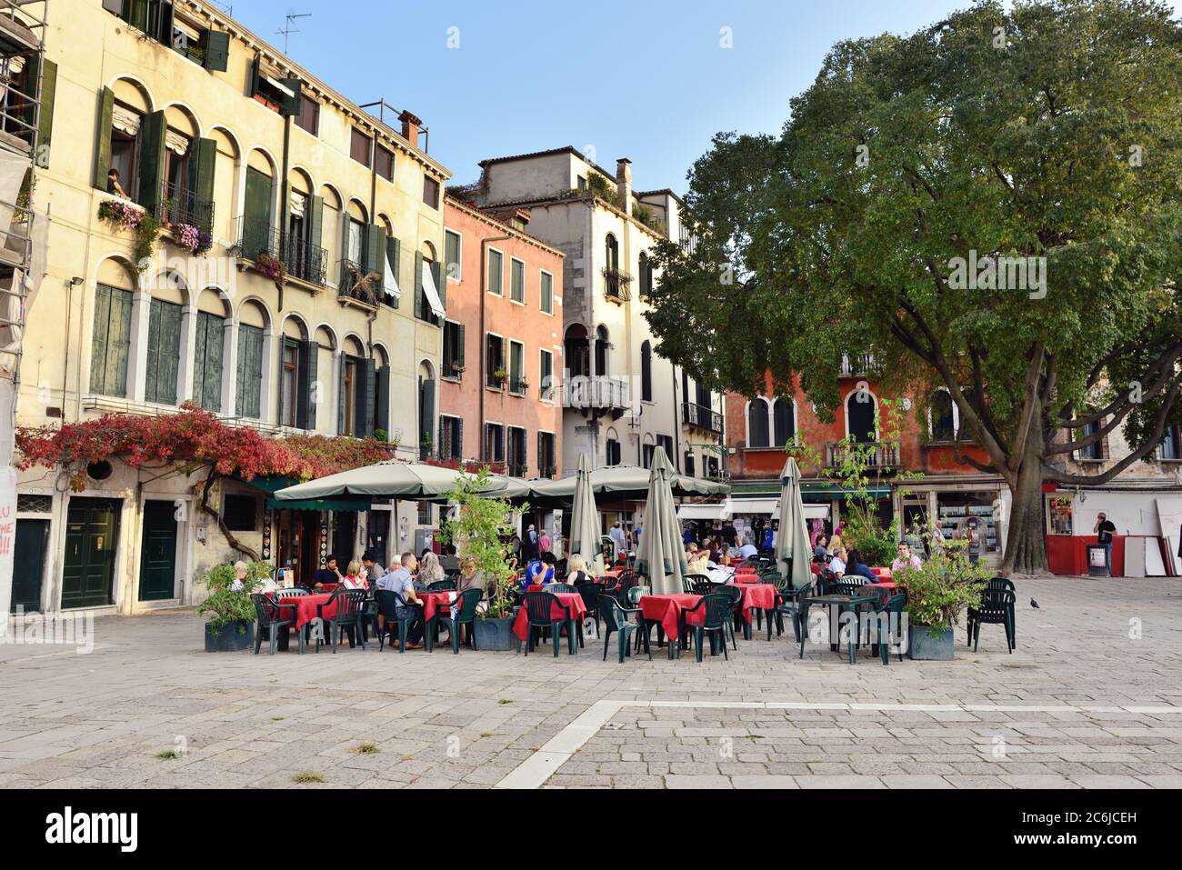 VENICE, ITALY - SEPT 21, 2014: People visit street cafe on square in Venice at evening time. This is the typical Venetian cafe Stock Photo