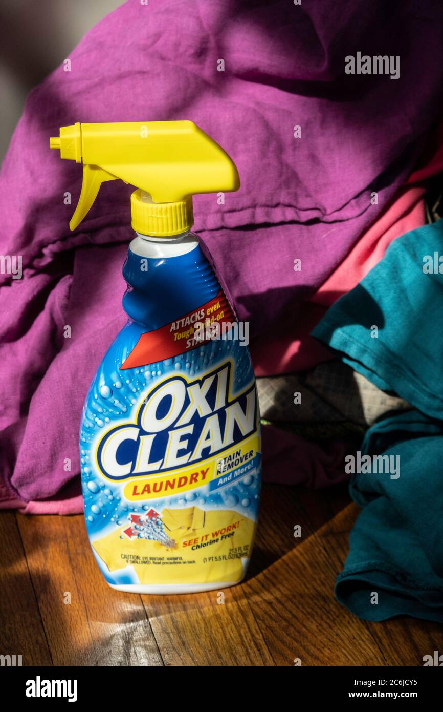 OxiClean laundry stain remover bottle with stack of dirty clothes, USA