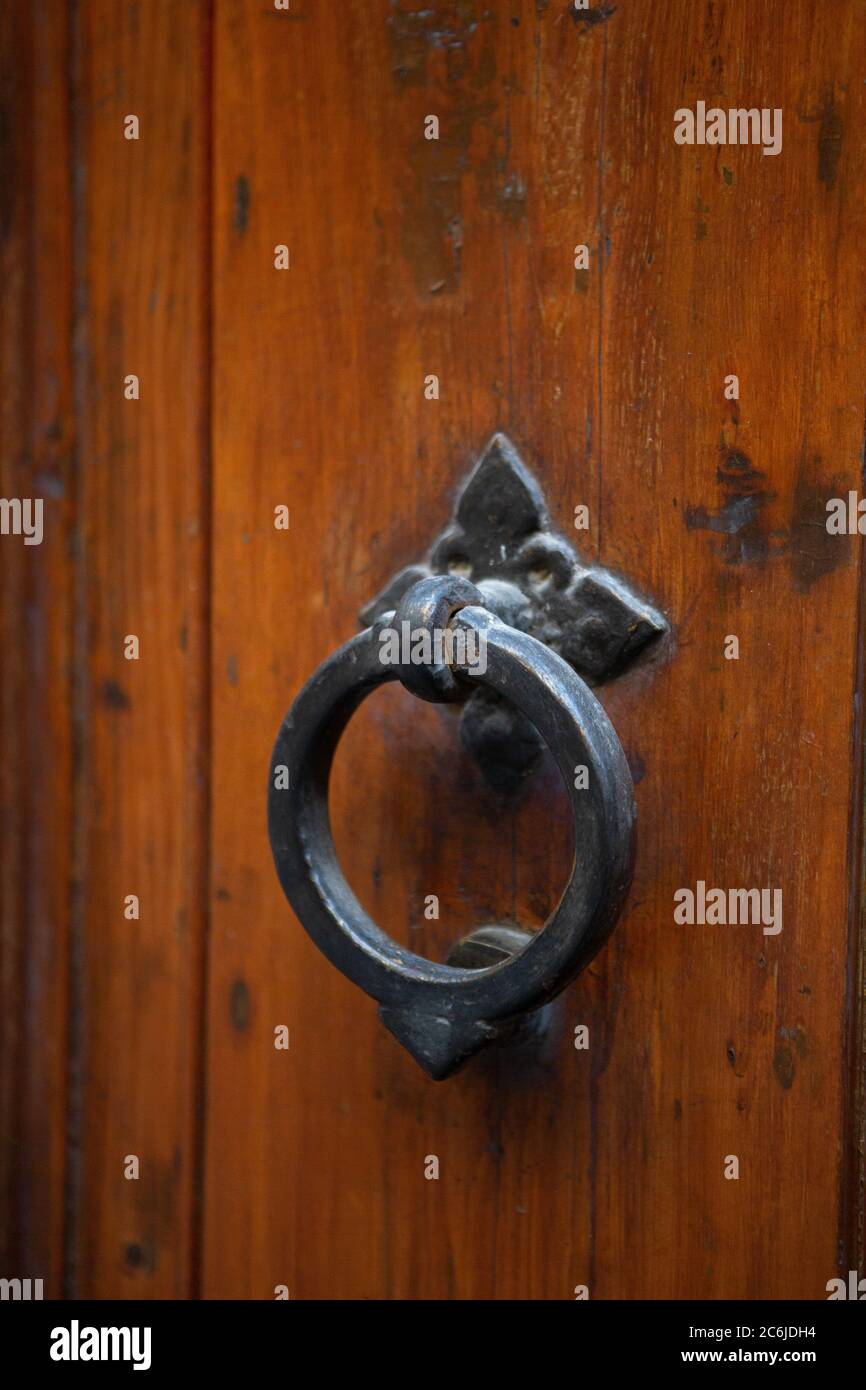 Antique metal doorknob circle shaped on brown front door. Vintage round handle on wooden entrance door. Close up shot Stock Photo