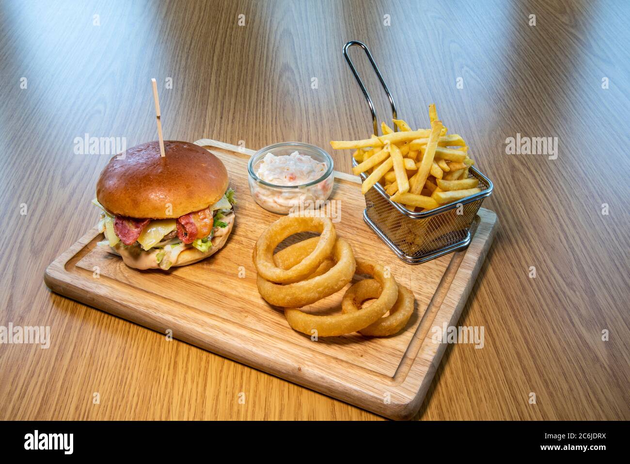 British pub food a serving of beef, bacon, cheese, and salad burger, chips and onion rings Stock
