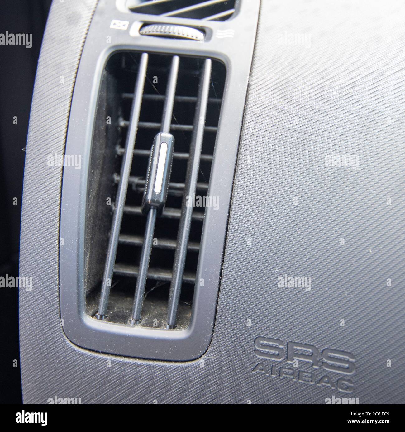 Driver hand tuning air ventilation grille, emergency flasher switch and  light in modern car interior Stock Photo - Alamy