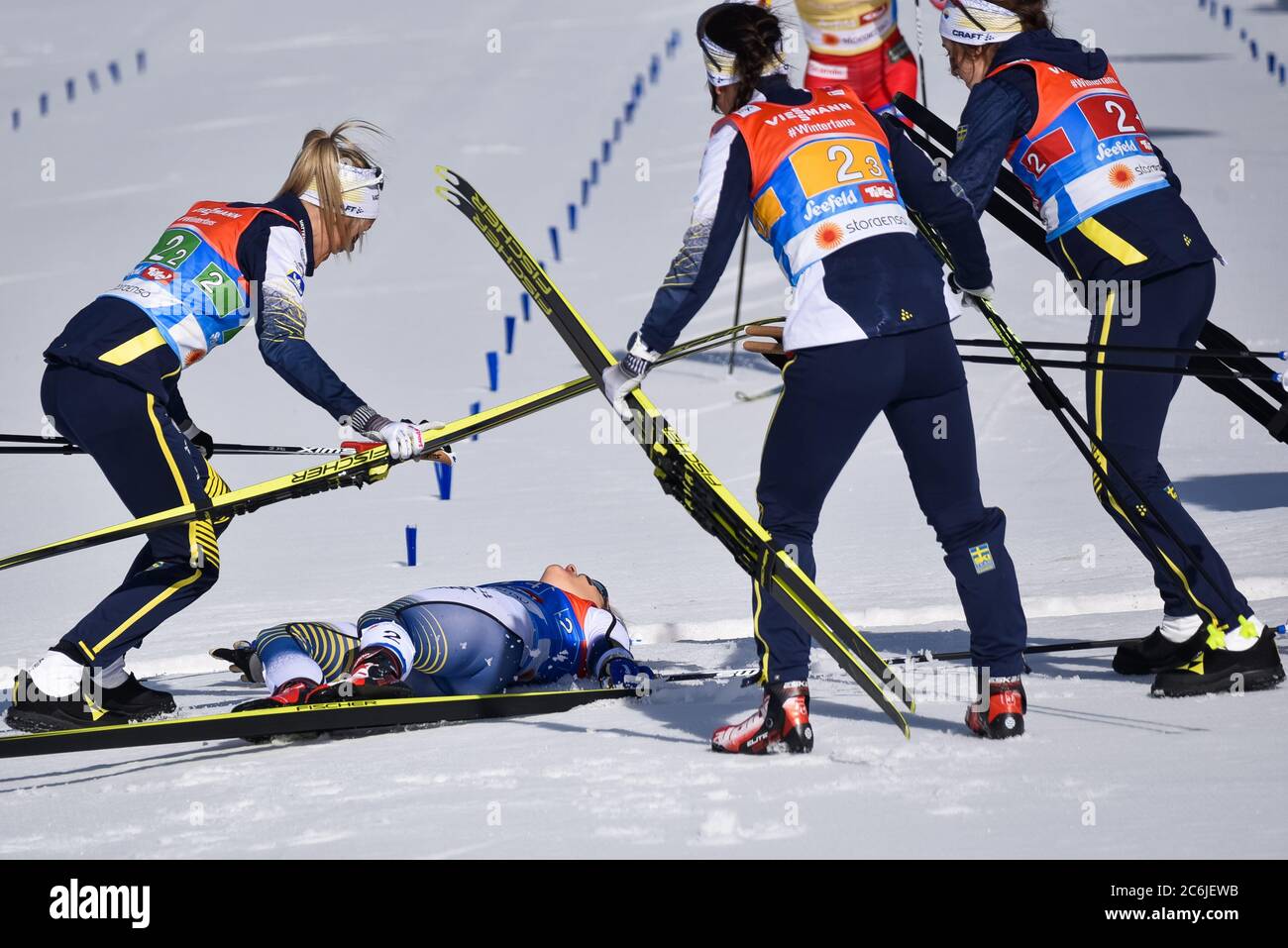 Swedish women celebrate after Stina Nilsson (on ground) wins women's cross-country  relay at the Nordic World Championships, Seefeld, Austria, 2019. Stock Photo