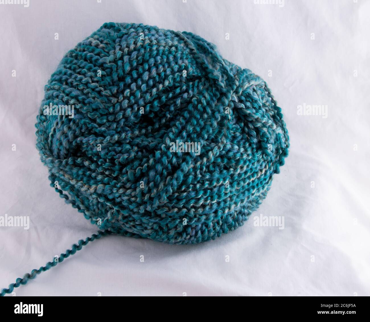 Multi Blue tones of spiral twisted yarn ball with strand leading to left Stock Photo