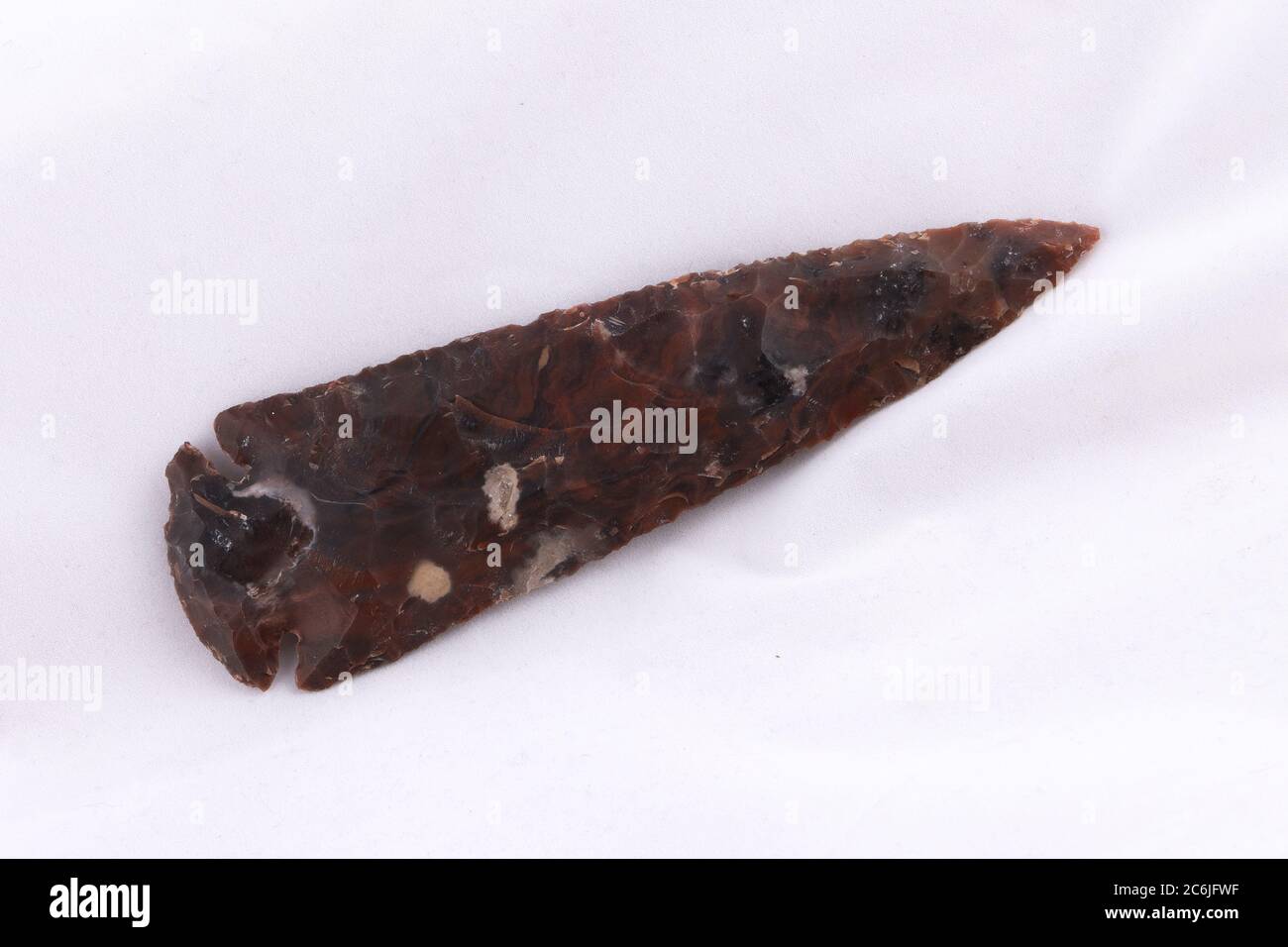 Isolated Stone Spear Head on white background, diagonal with copy space Stock Photo