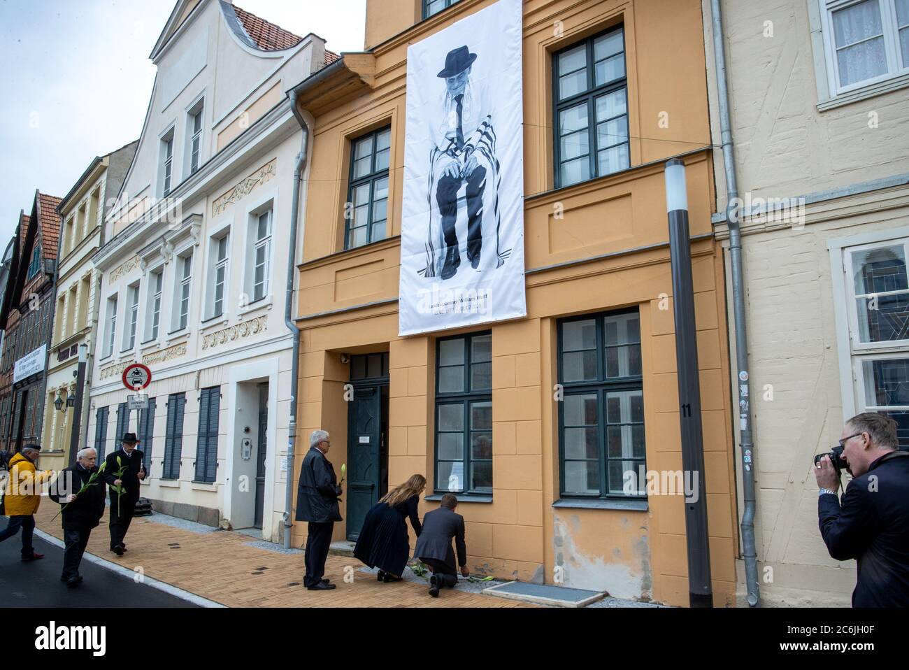 Schwerin, Germany. 10th July, 2020. About 150 people said their farewells to William Wolff, the long-time state rabbi in Mecklenburg-Western Pomerania, with a prayer service. In front of the Jewish Community building, where a picture of the rabbi by the photographer Koska was hung, mourners laid flowers. Wolff had died in England on 08.07.2020 at the age of 93. Credit: Jens Büttner/dpa-Zentralbild/dpa/Alamy Live News Stock Photo