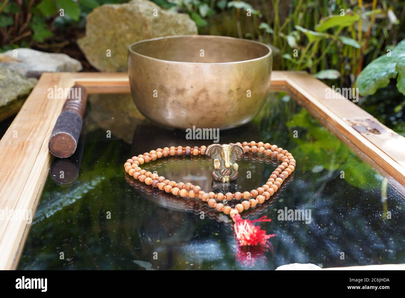 Tibetan singing bowl close up with beautiful woodon Mala and Ganesha Deity for sound healing Stock Photo