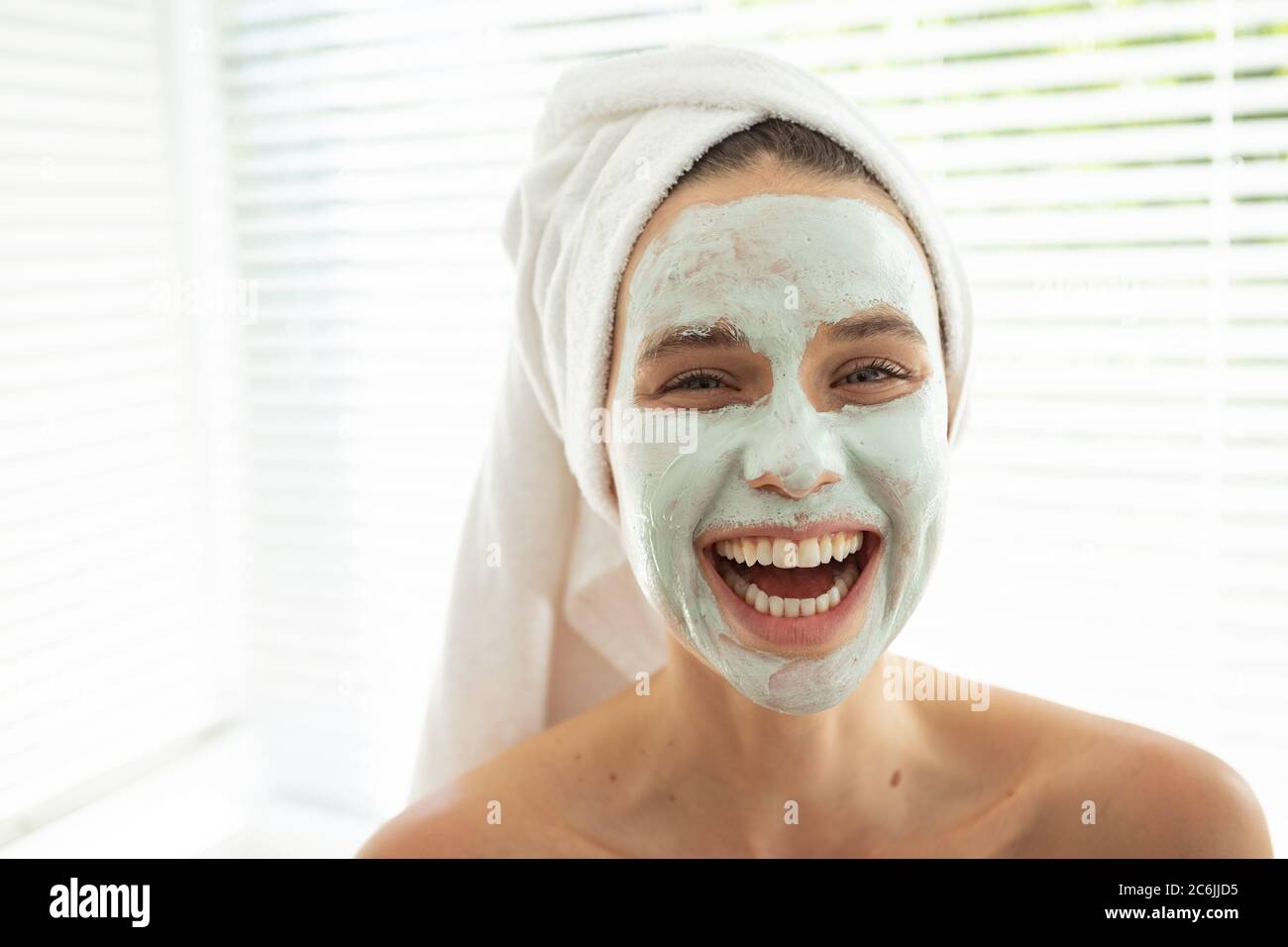 Portrait of woman with face pack smiling Stock Photo