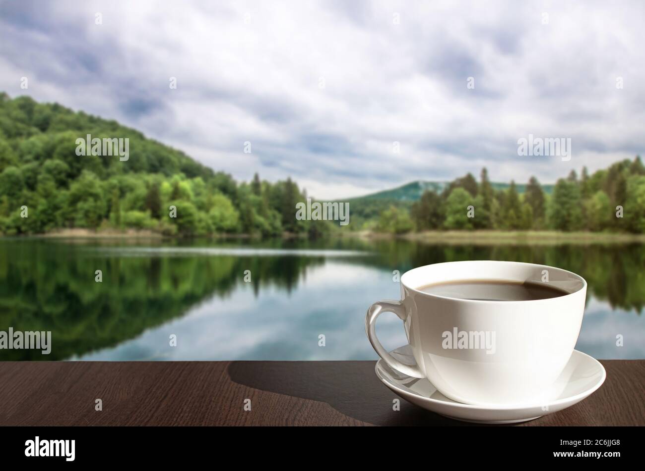 Cup of black coffee or tea with lake in the forest background in Croatia Stock Photo