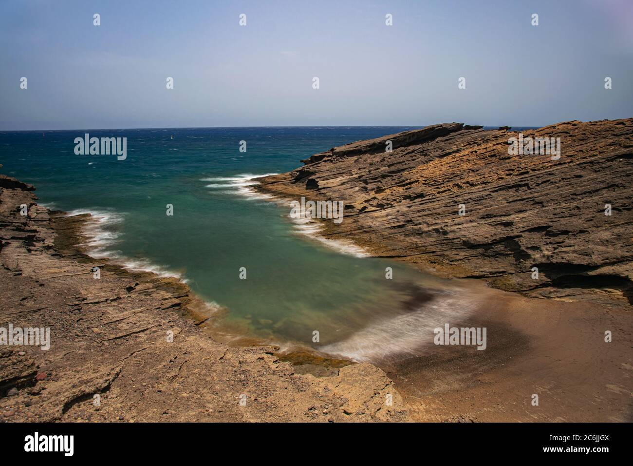 Secret beach in El Medano, long exposure, Volcanic rocks formation eroded by the wind and sea, Tenerife, Canary islands, Spain Stock Photo