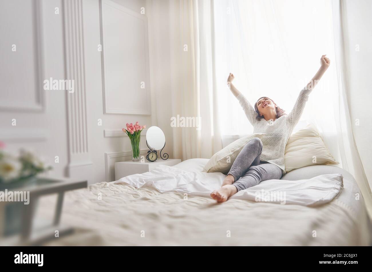 Happy young woman enjoying sunny morning on the bed Stock Photo - Alamy