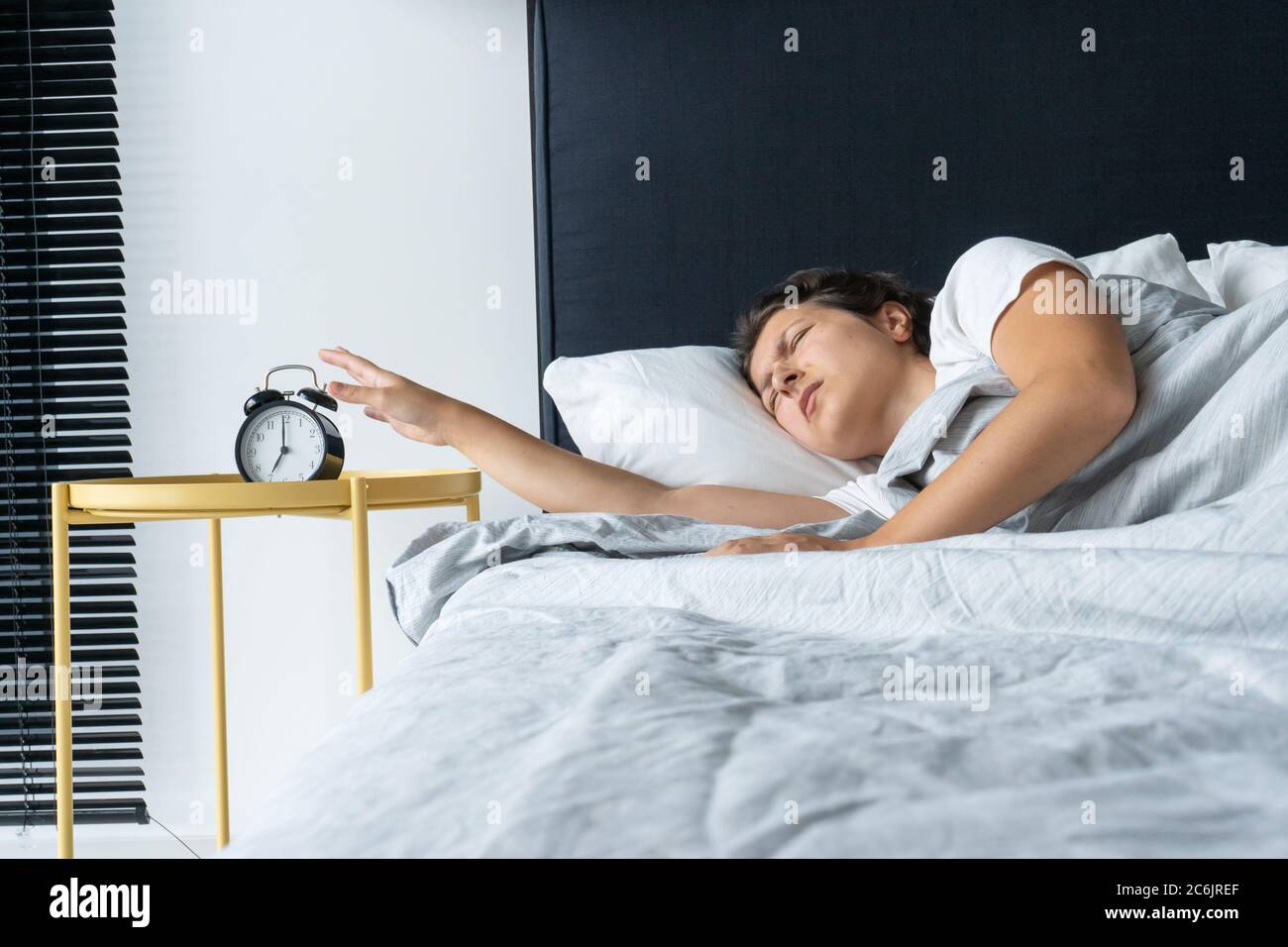 The Girl Turns Off The Annoying Alarm Clock To Continue Sleeping Get Some More Sleep It A Hard Morning Time To Wake Up Stock Photo Alamy