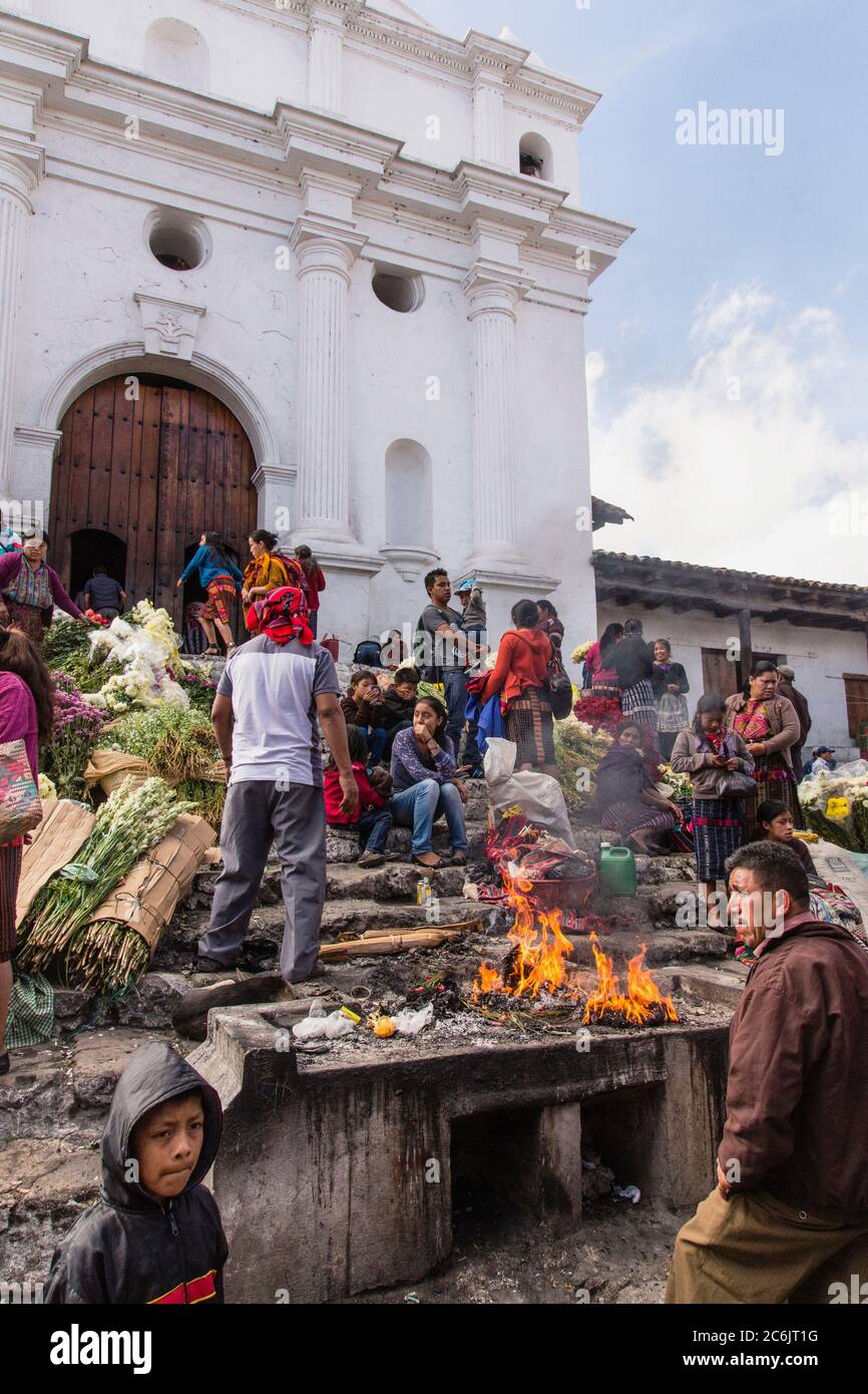 Guatemala, El Quiche Department, Chichicastenango, An offering to the Mayan gods burns on an altar on the steps of the Church of Santo Tomas. The church was built on the platform of a Mayan temple pyramid, and Mayans still make offerings on the steps of the pyramid. Stock Photo