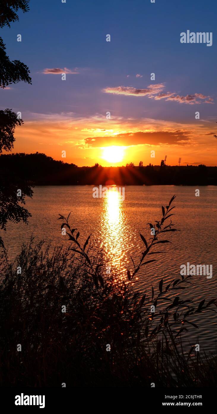 Amazing sunrise over a lake. Rays of the sun reflecting on the water ...