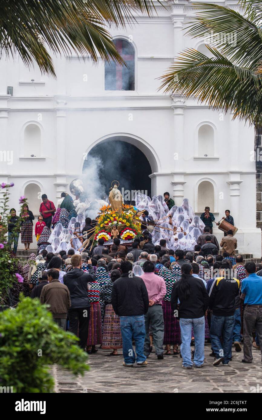 Guatemala, Solola Department, San Pedro la Laguna, Catholic procession of the Virgin of Carmen. Women in traditional Mayan dress with white mantillas over their heads.  Women carry the image of the Virgin in the procession. Stock Photo
