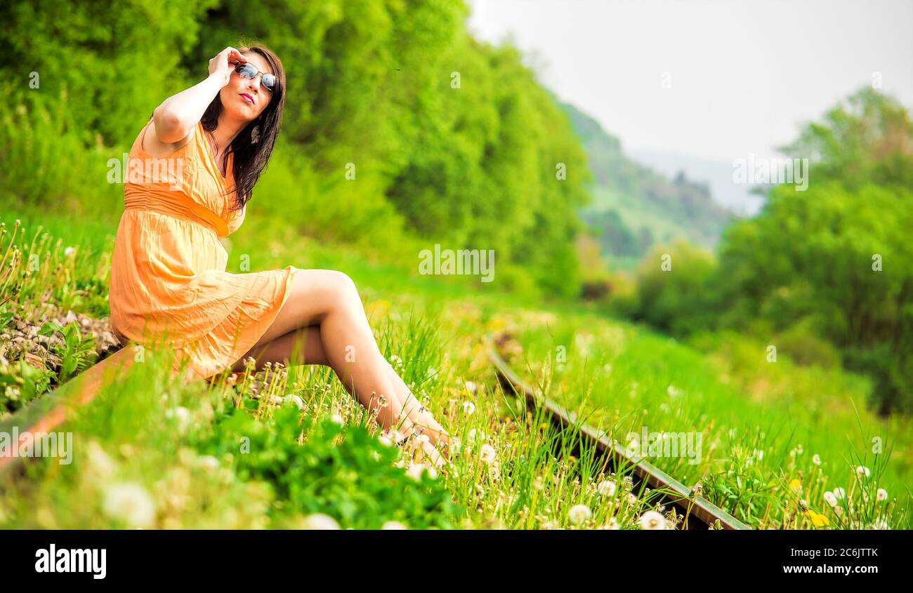 Fashion photo of a woman sitting on train tracks Stock Photo Alamy