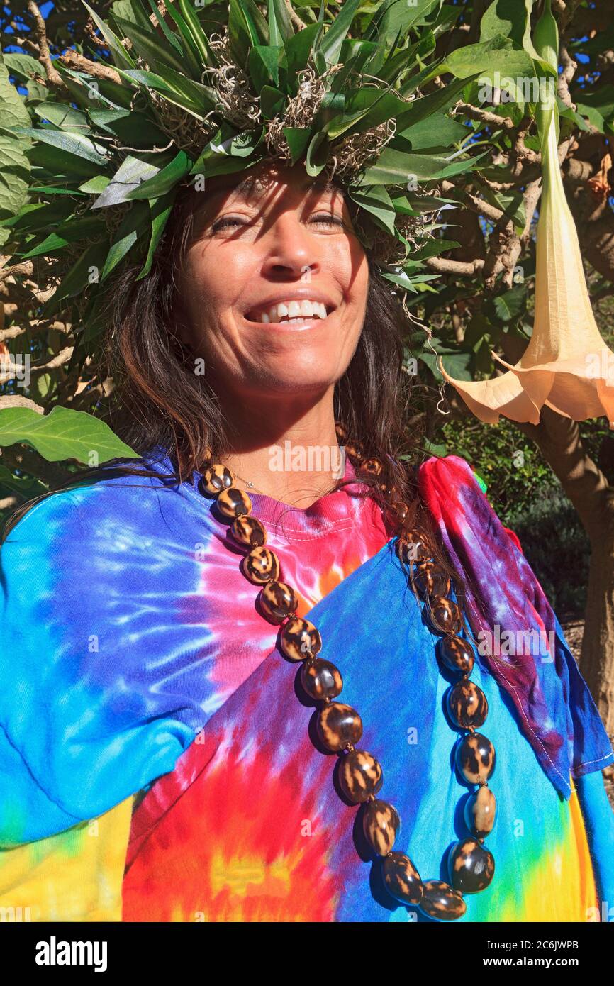 Barbara Bohonu, spiritual/cultural healer by a angels trumpet flower tree (Brugmansia candida), Maui, Hawaii, USA Stock Photo