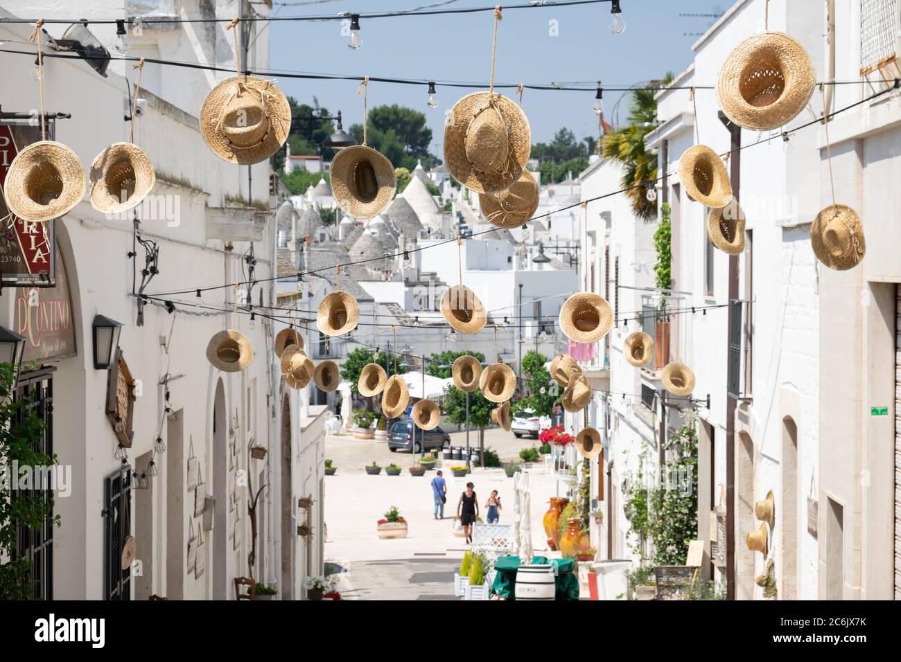 Puglia, South Italy - Alberobello, a special view of an artful installation of straw hats in a small street in the small Unesco town. Stock Photo