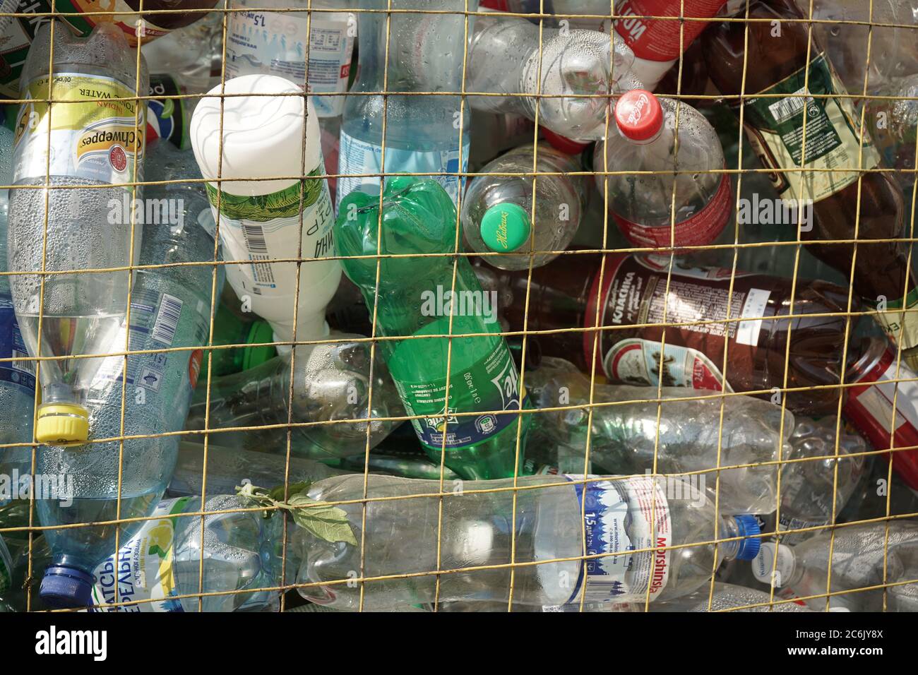 Empty plastic bottles in trash can. Grated trash container with discarded plastic or pet packaging. Environment and ecology concept. Recyclable Stock Photo