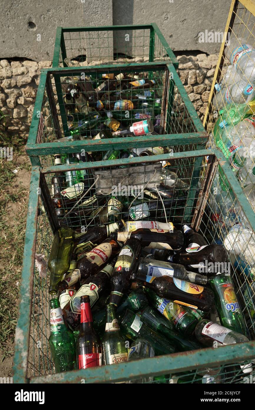 Used discarded glass bottles in trash or garbage containers. Garbage recycling concept. August 2018, Odessa, Ukraine Stock Photo