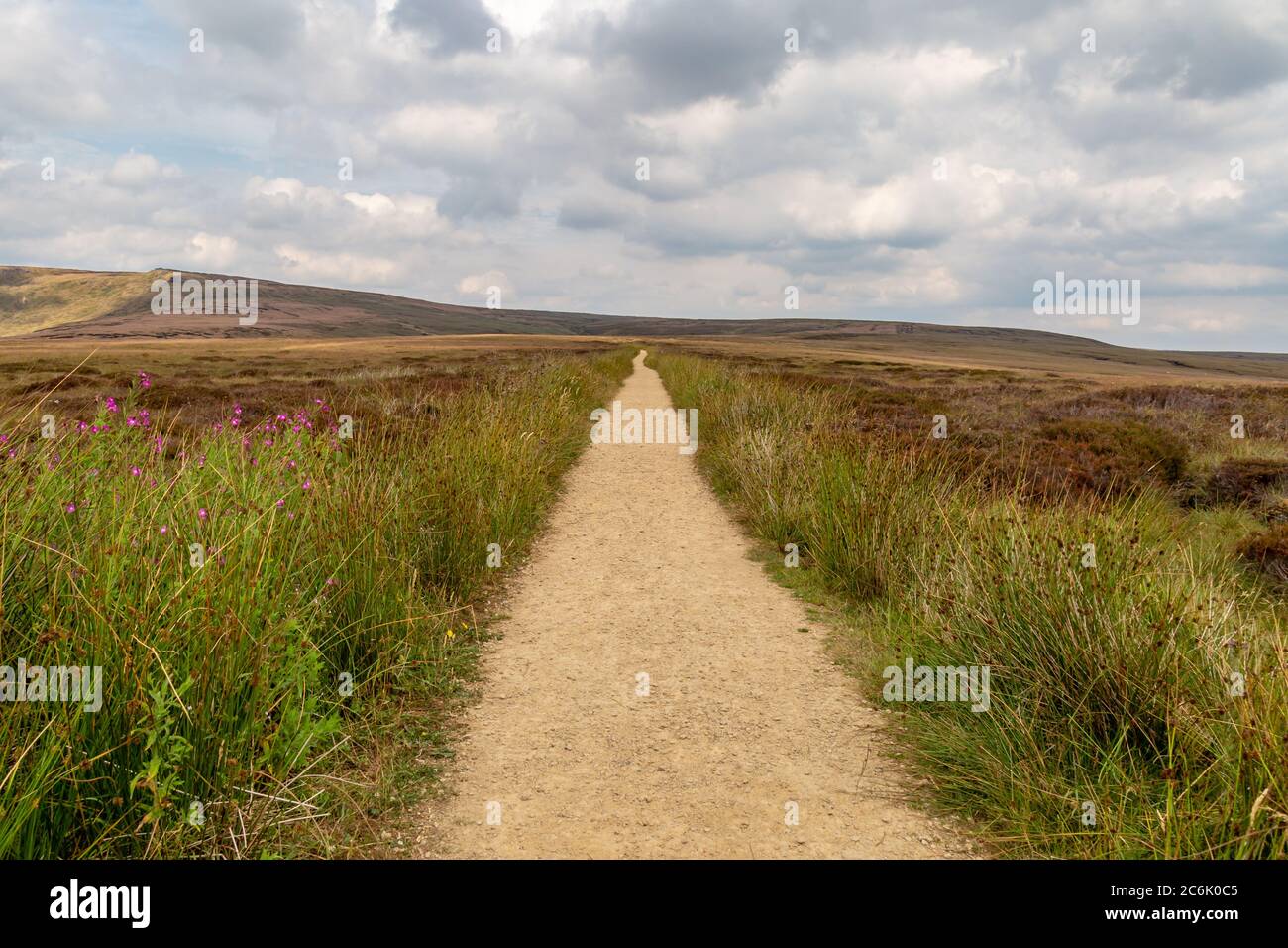 Looking down an empty pathway along the Pennine Way in Derbyshire, with a cloudy sky overhead Stock Photo